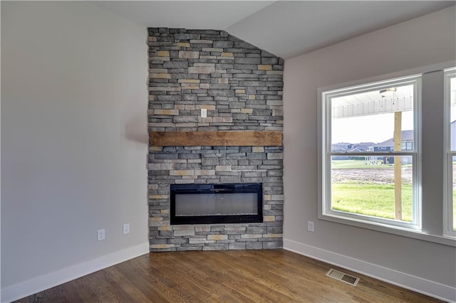 unfurnished living room with hardwood / wood-style floors, a fireplace, a wealth of natural light, and vaulted ceiling