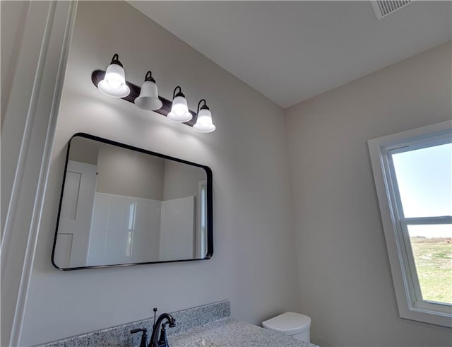 bathroom featuring vanity, toilet, and walk in shower