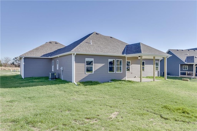 rear view of property with central AC, a patio area, and a yard