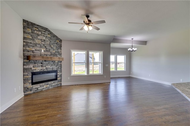 unfurnished living room featuring vaulted ceiling, a fireplace, dark hardwood / wood-style flooring, and ceiling fan with notable chandelier