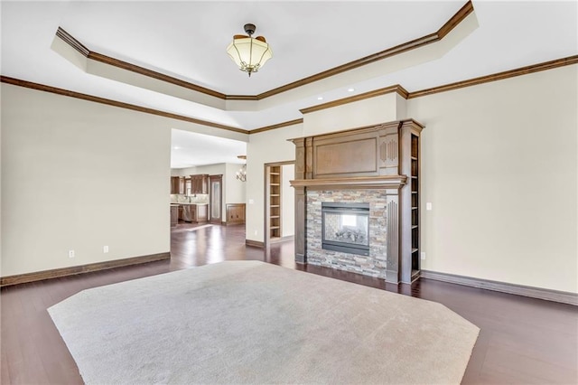 unfurnished bedroom featuring a stone fireplace, multiple windows, ornamental molding, and dark hardwood / wood-style flooring