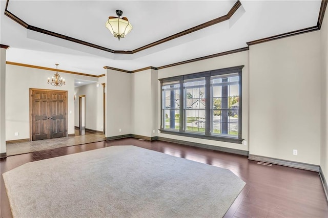 interior space with ornamental molding, a chandelier, a tray ceiling, and dark hardwood / wood-style flooring