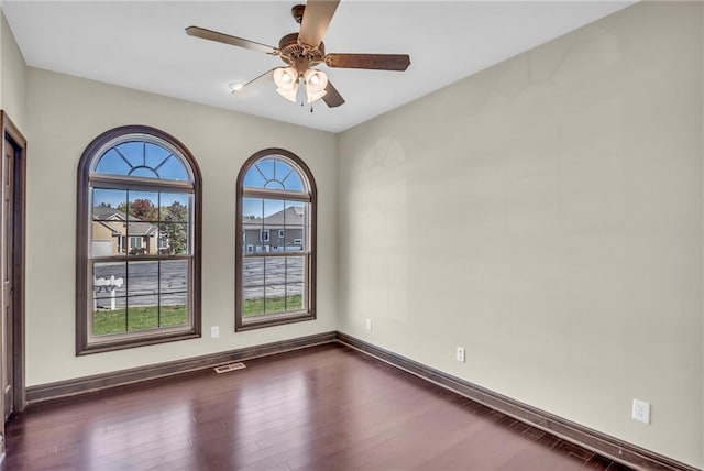 spare room with dark wood-type flooring and ceiling fan