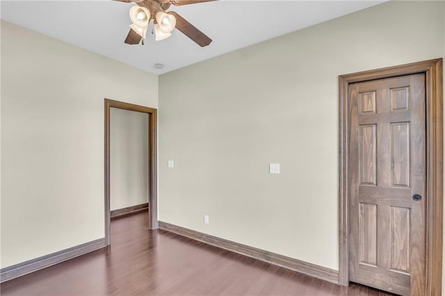 spare room featuring dark wood-type flooring and ceiling fan