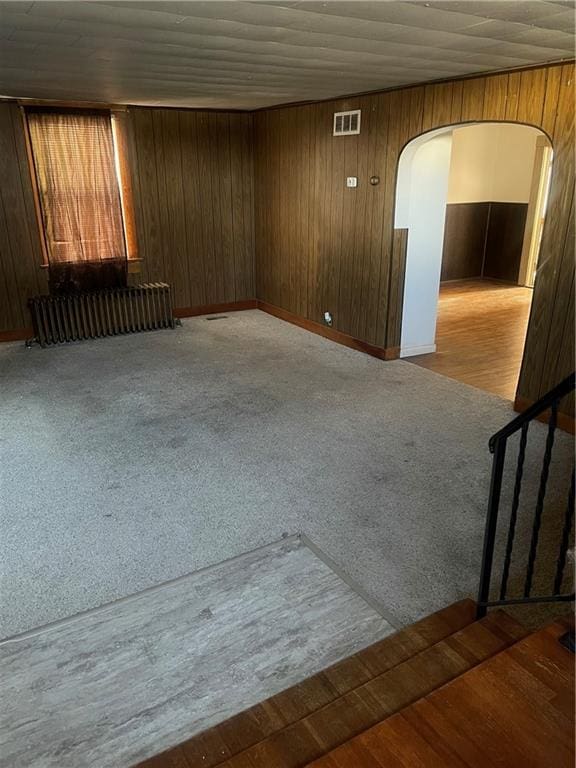 empty room featuring wood walls and hardwood / wood-style floors