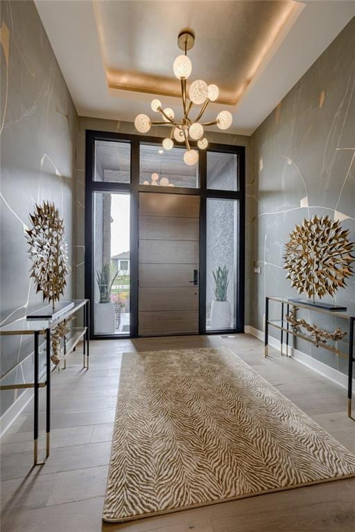 4511 W 136th St, Leawood, KS 66224 - foyer entrance featuring a tray ceiling, an inviting chandelier, and light wood-style floors