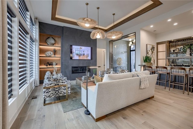 4511 W 136th St, Leawood, KS 66224 - living room featuring visible vents, a tray ceiling, recessed lighting, wood finished floors, and a tiled fireplace