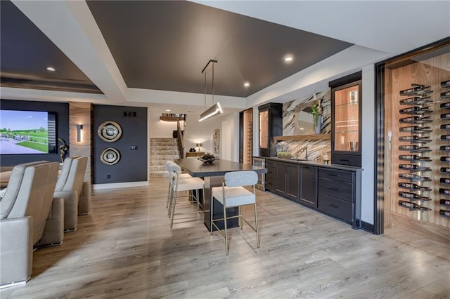 4511 W 136th St, Leawood, KS 66224 - dining room featuring a raised ceiling, baseboards, light wood-style flooring, and stairs