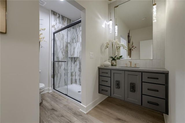 4511 W 136th St, Leawood, KS 66224 - full bathroom featuring wood finished floors, toilet, vanity, visible vents, and a stall shower
