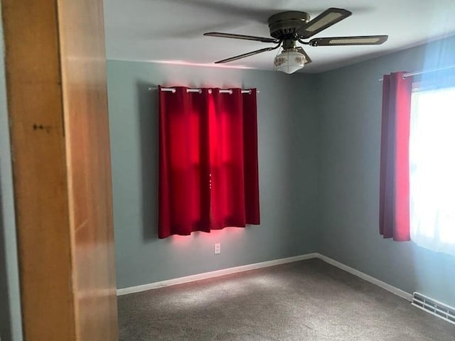 spare room with ceiling fan and carpet