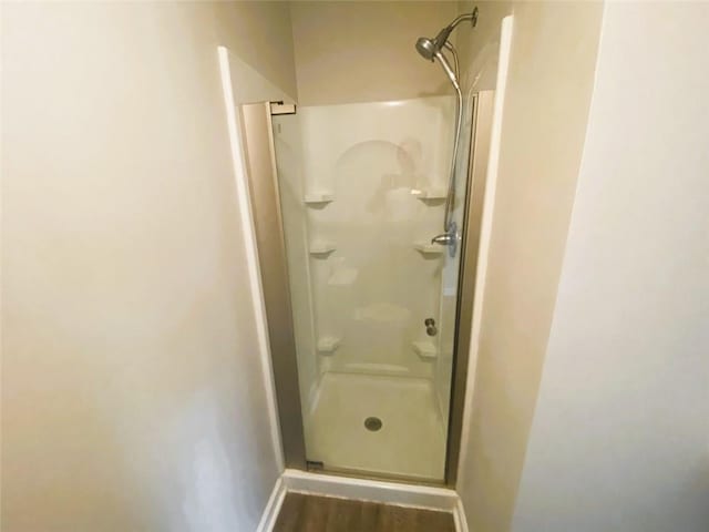 bathroom featuring wood-type flooring and a shower with door