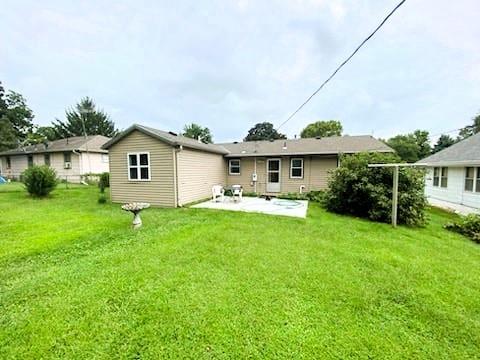 rear view of property with a lawn and a patio area