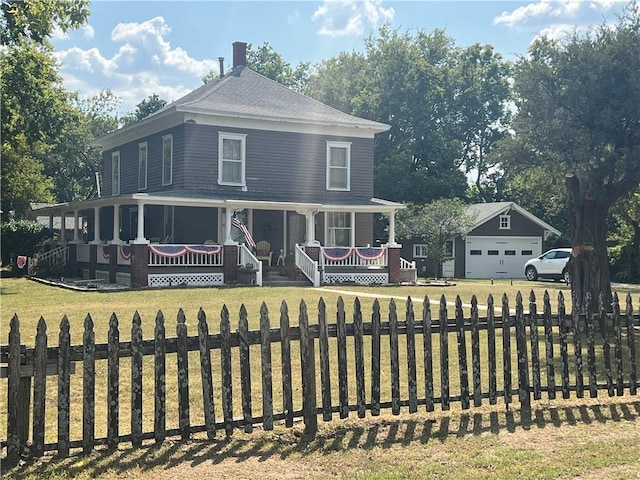 country-style home with a garage, a front yard, a sunroom, and an outbuilding