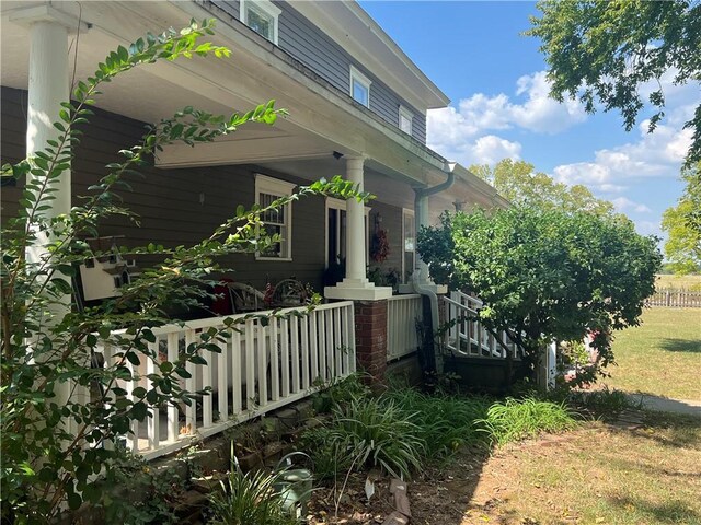 view of property exterior with a yard and a porch