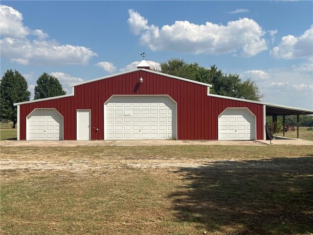 garage featuring a yard and a carport