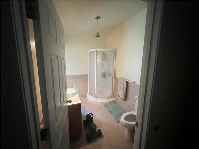 bathroom featuring walk in shower, toilet, vanity, and tile patterned flooring