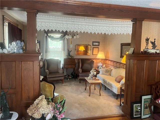 sitting room with ornate columns and carpet floors