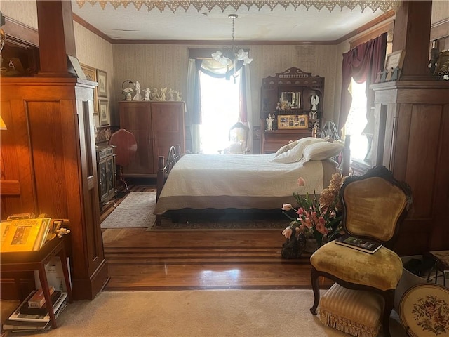 bedroom featuring ornamental molding, a notable chandelier, and light hardwood / wood-style floors