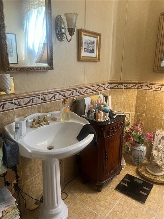 bathroom featuring tile walls, tile patterned floors, and decorative backsplash