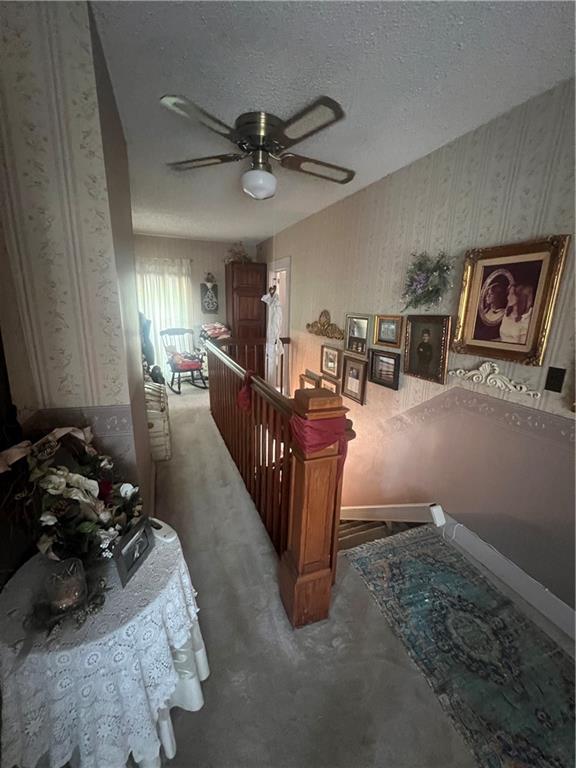 bedroom featuring a textured ceiling, ceiling fan, and carpet