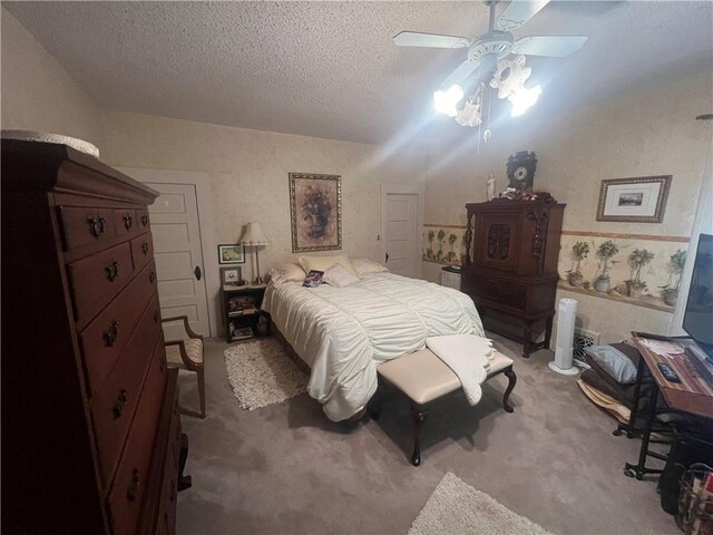 carpeted bedroom with a textured ceiling and ceiling fan