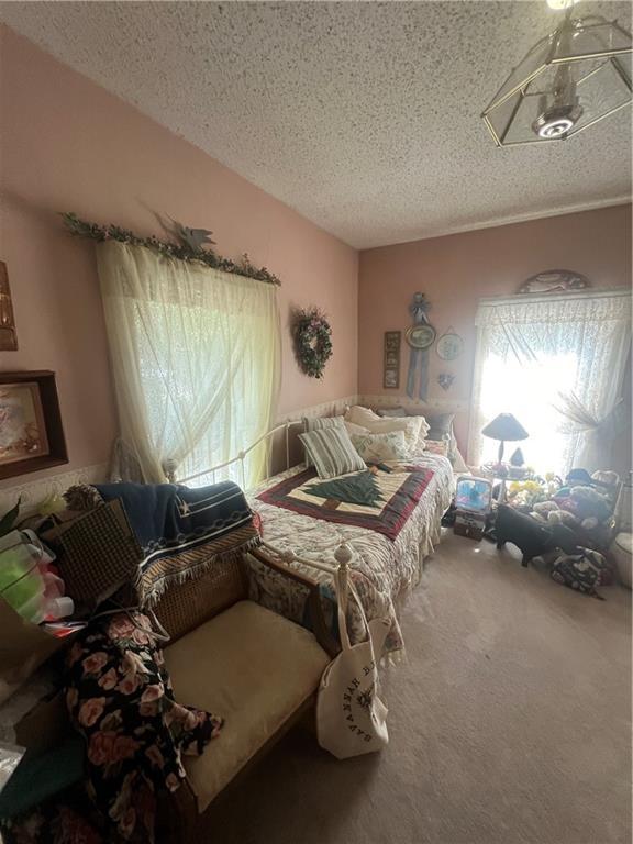 bedroom featuring a textured ceiling and carpet floors