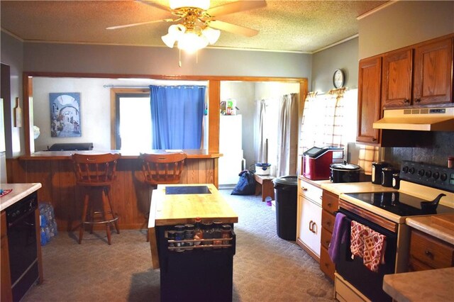 kitchen with light colored carpet, butcher block countertops, electric range oven, ceiling fan, and a textured ceiling