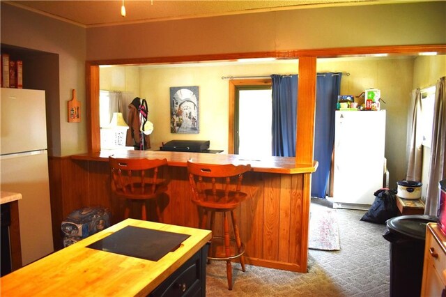 kitchen featuring carpet flooring, wooden counters, white fridge, and ornamental molding