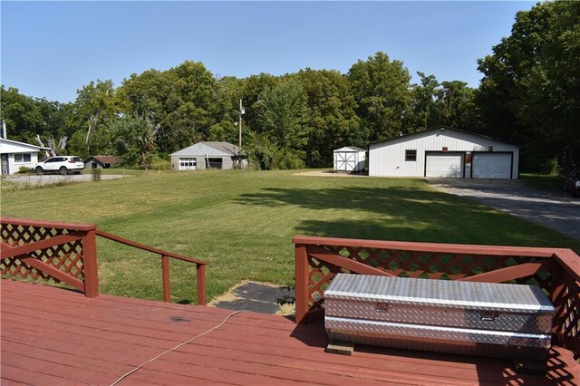 wooden terrace featuring a garage, a storage shed, and a yard