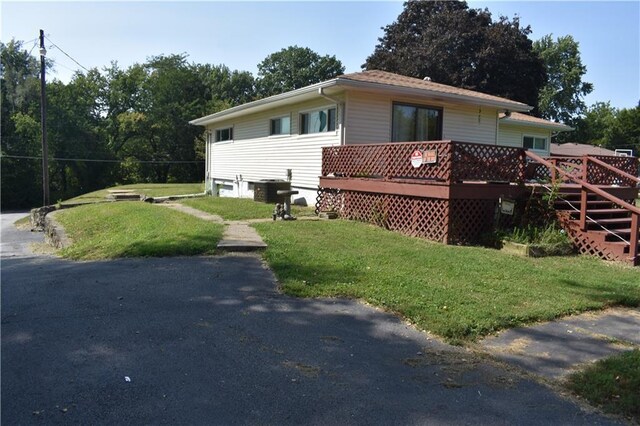 view of home's exterior featuring a yard and a deck