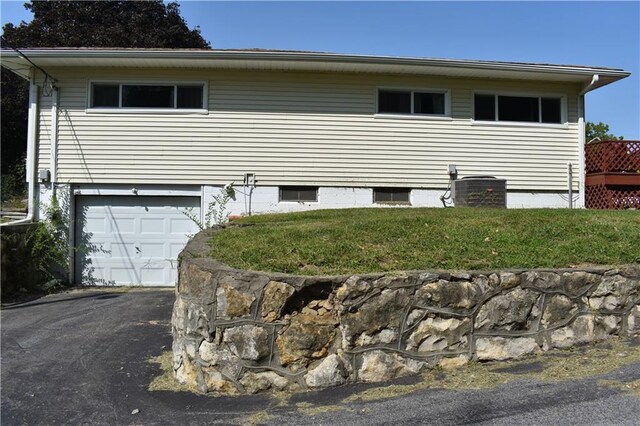 view of front of property with a garage and central AC