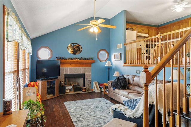 living room featuring a tile fireplace, dark wood-type flooring, ceiling fan, and high vaulted ceiling