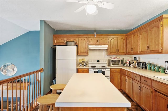 kitchen with white appliances, ceiling fan, a center island, and backsplash