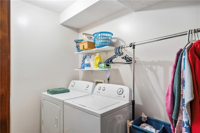 washroom with a textured ceiling and washing machine and clothes dryer