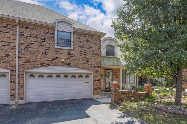 view of front of home with brick siding, aphalt driveway, and a garage