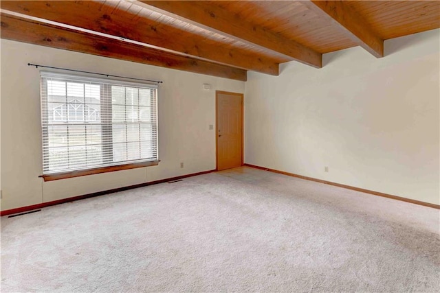 empty room with beam ceiling, visible vents, carpet flooring, wooden ceiling, and baseboards