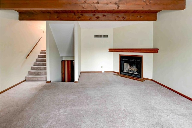 unfurnished living room featuring visible vents, baseboards, a fireplace with flush hearth, stairway, and carpet floors