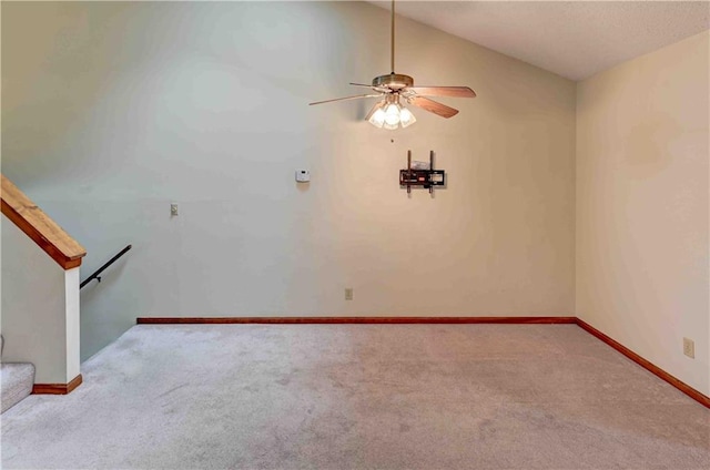 empty room with baseboards, ceiling fan, vaulted ceiling, and light colored carpet