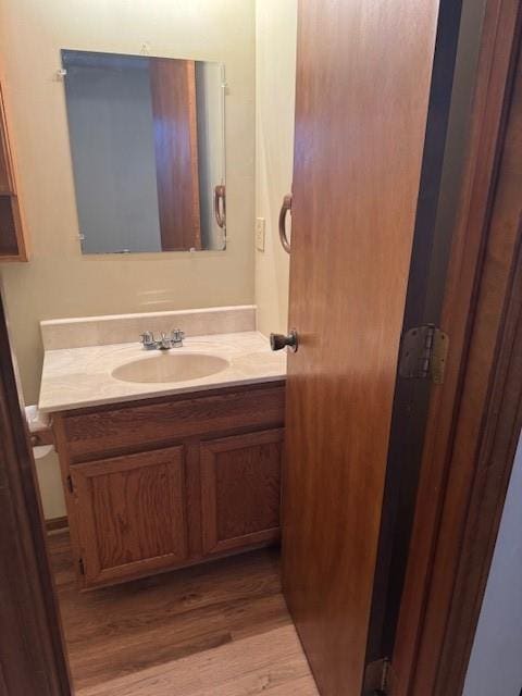 half bathroom featuring wood finished floors and vanity