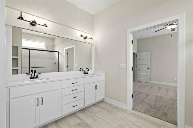 bathroom featuring ceiling fan, a shower with door, and vanity