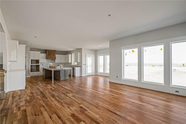unfurnished living room with wood finished floors and baseboards