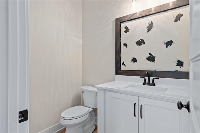 half bathroom with vanity and toilet