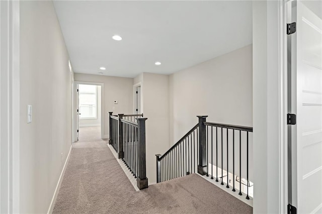 hall with an upstairs landing, carpet flooring, recessed lighting, and baseboards