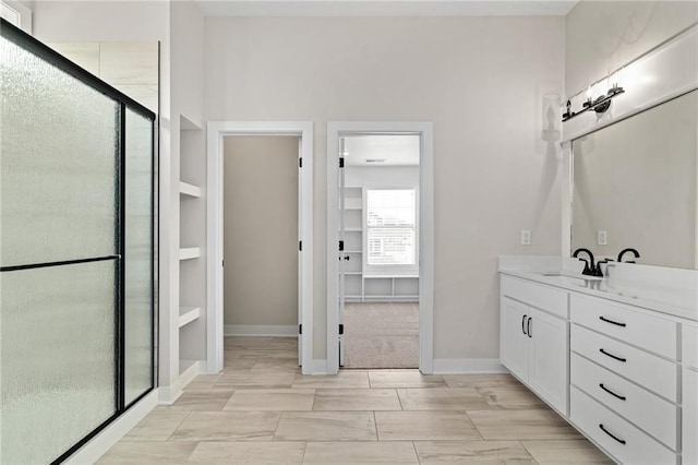bathroom featuring a stall shower, vanity, and baseboards