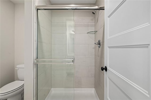 bathroom with toilet and a stall shower