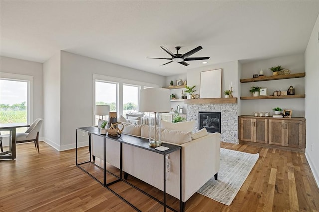 25010 W 142nd St, Olathe, KS 66061 - living room with light wood-style flooring, ceiling fan, and a fireplace