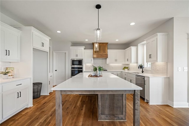 25010 W 142nd St, Olathe, KS 66061 - kitchen with appliances with stainless steel finishes, a center island, backsplash, white cabinetry, and wood finished floors