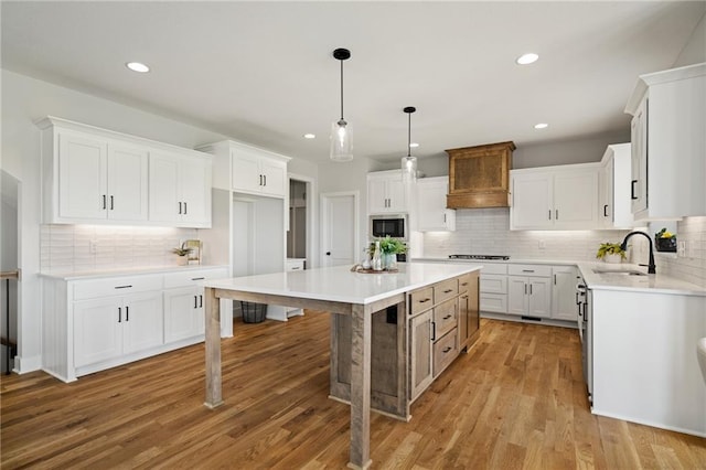 25010 W 142nd St, Olathe, KS 66061 - kitchen featuring a center island, stainless steel microwave, gas cooktop, backsplash, and custom range hood