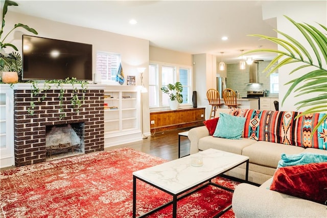 living room with a brick fireplace and dark hardwood / wood-style flooring