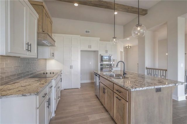 kitchen with stainless steel appliances, a sink, visible vents, light wood finished floors, and tasteful backsplash